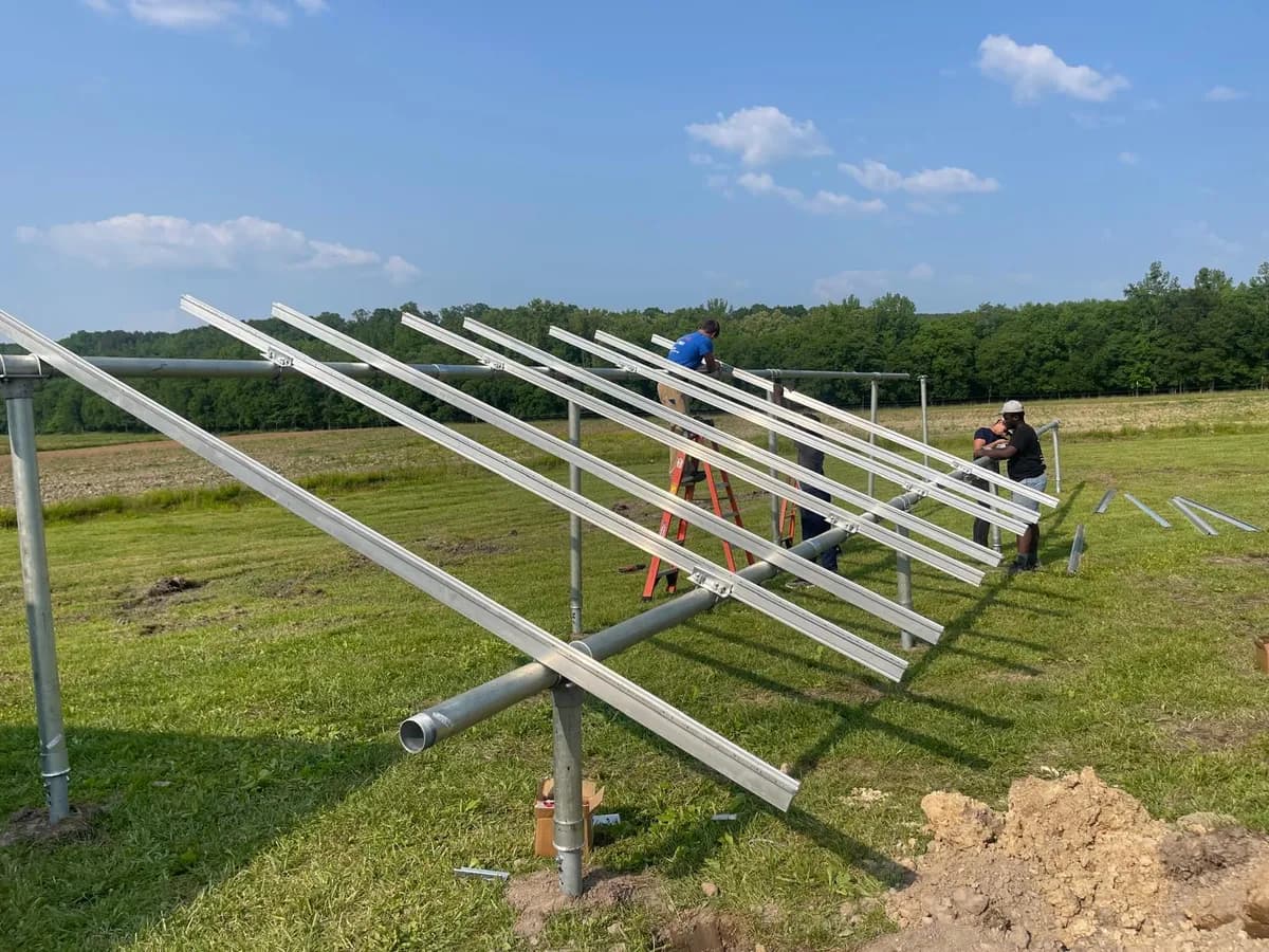 Ground-mount solar racking being assembled in an open field